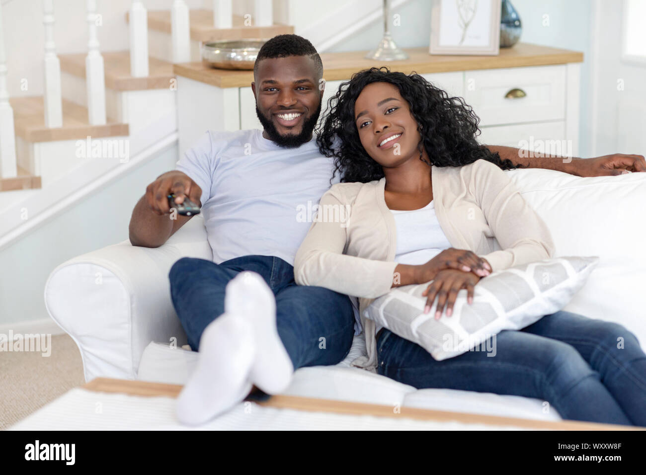 Smiling african american couple relaxing and watching TV at home Stock ...