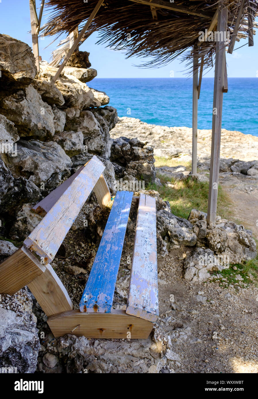A bench overlooks the sea at North Point, Barbados Stock Photo