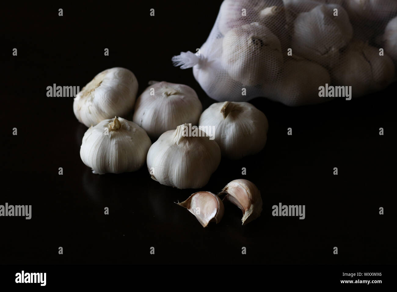 Garlic bulbs against plain black background Stock Photo