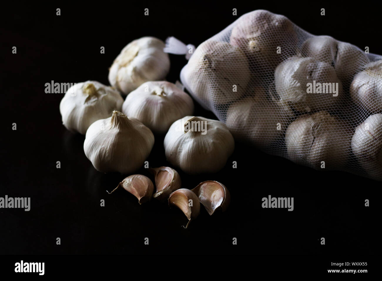 Garlic bulbs against plain black background Stock Photo