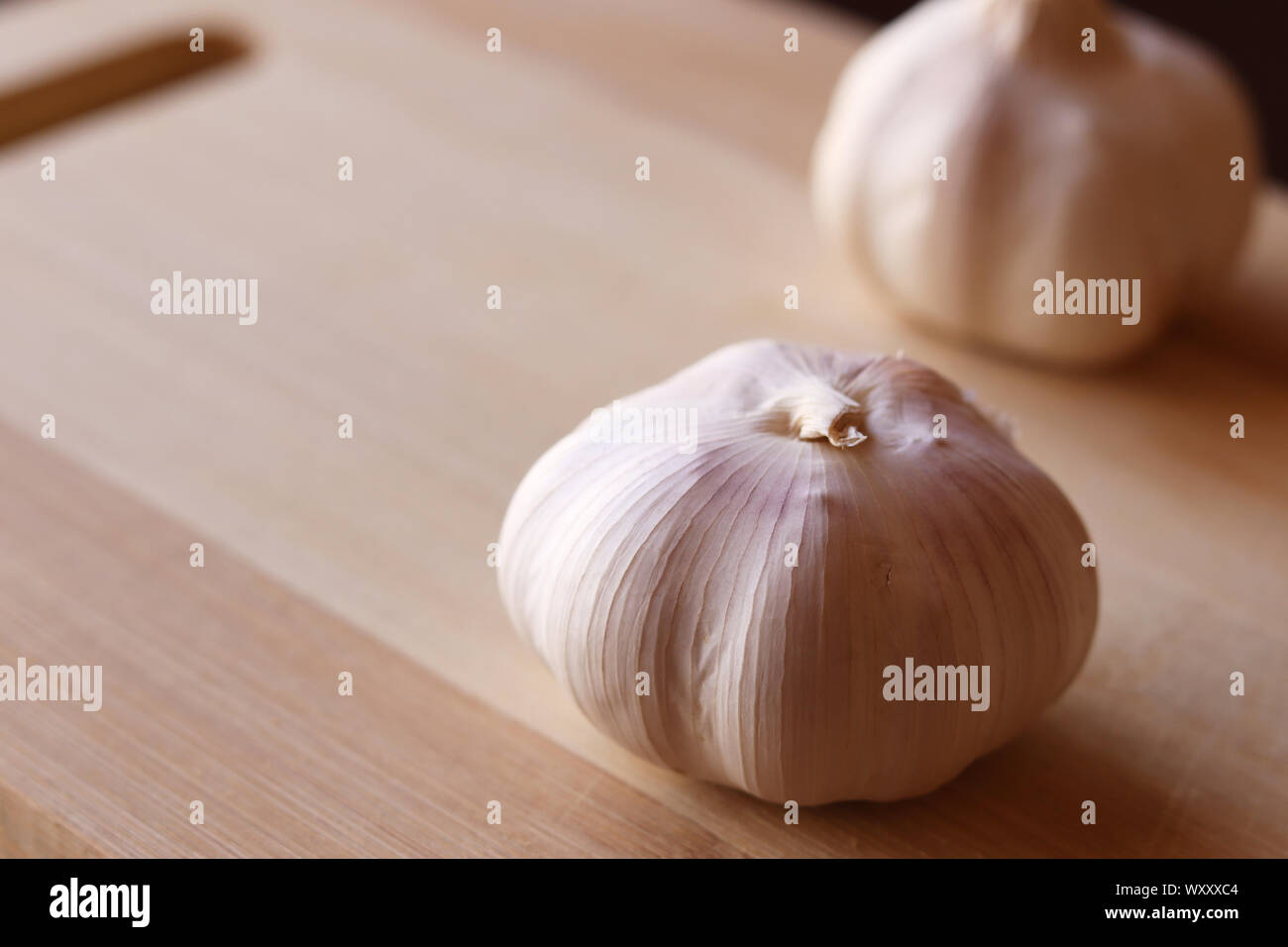 Garlic bulbs on wood cutting board using natural light Stock Photo