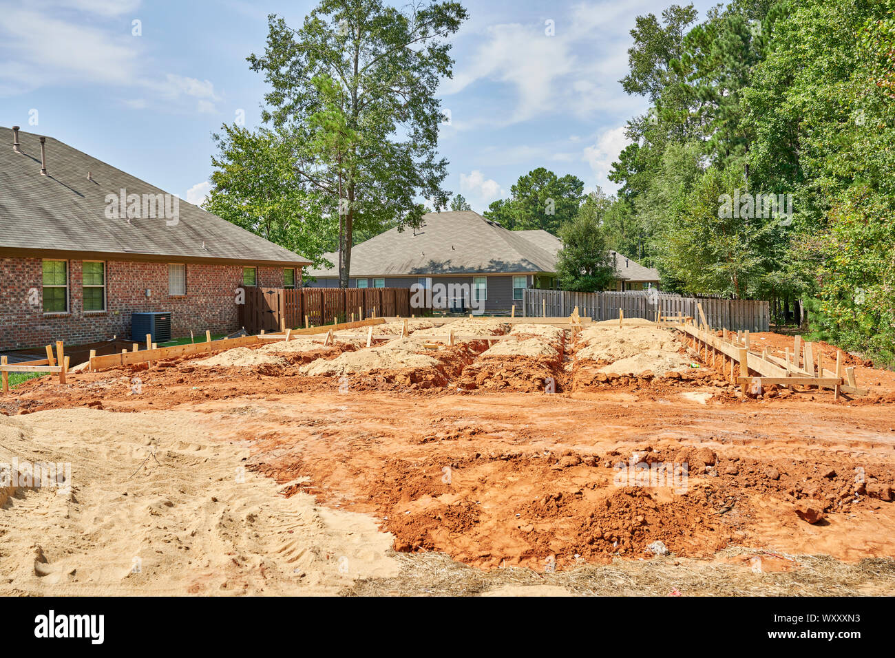 New house or home under construction with foundation framing set and plumbing trenches dug in a suburban neighborhood in Montgomery Alabama, USA. Stock Photo