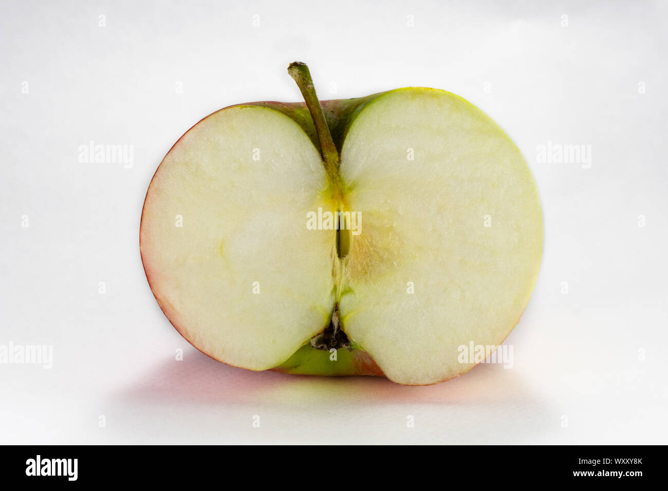Bright vibrant fresh apple sliced in half. Photography taken on white backgound with macro lens. Stock Photo