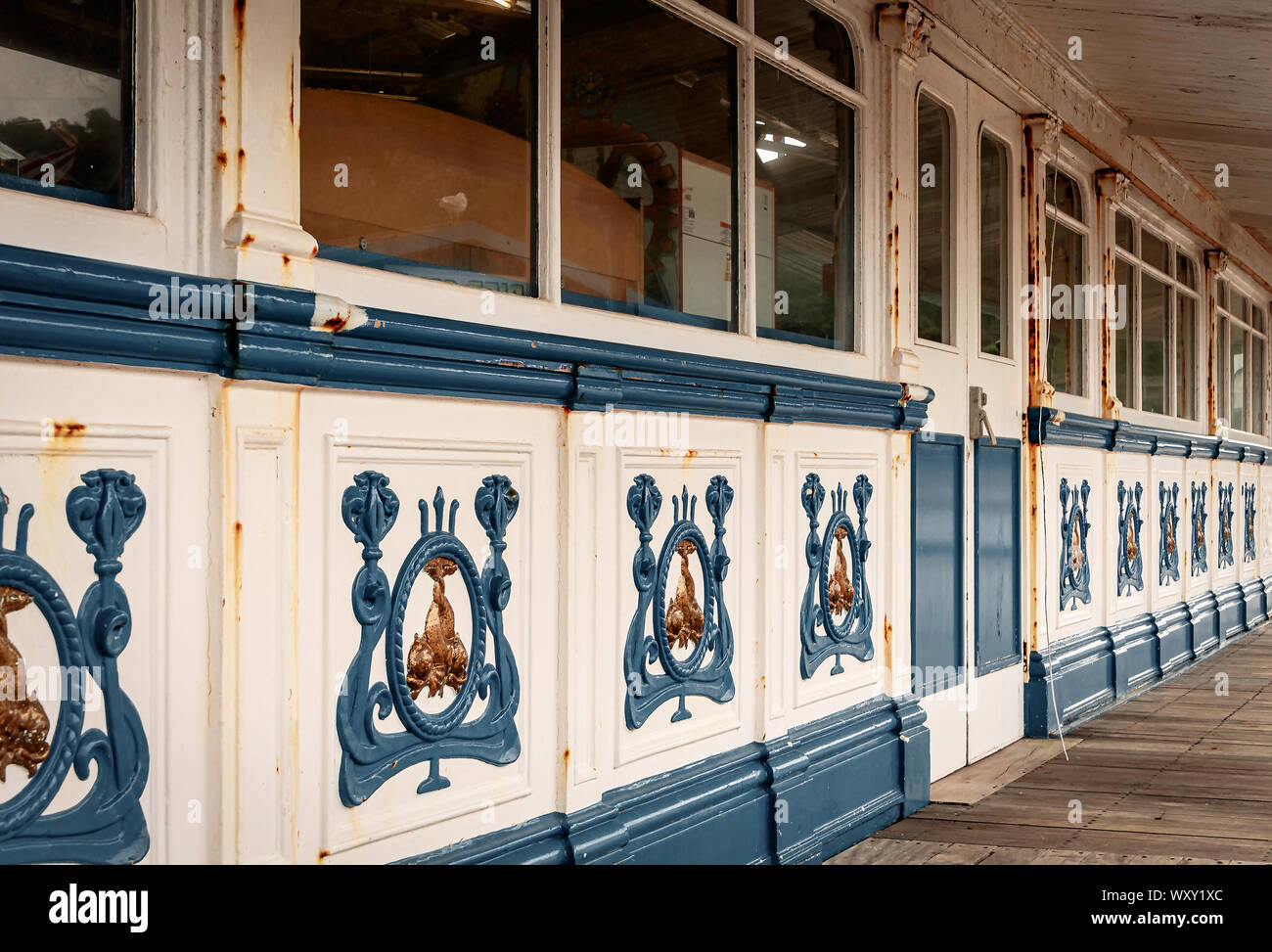 The side of the amusement arcade on Llandudno pier.  Backs of cabinets are against the windows and emblems adorn the wooden panels. The metalwork is r Stock Photo