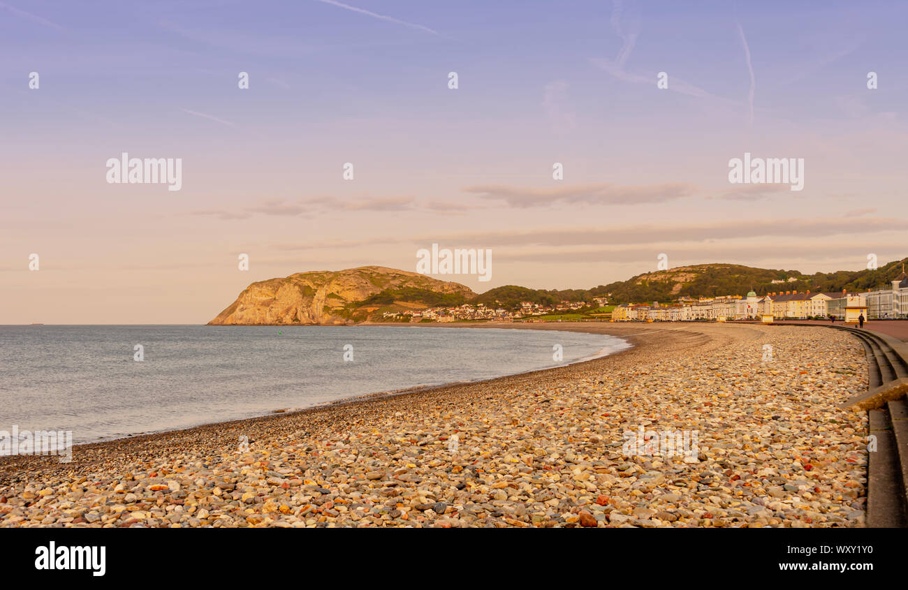 A view of Llandudno’s curving shoreline at dusk..  The Little Orme headland is in the distance and a fading blue sky is above. Stock Photo