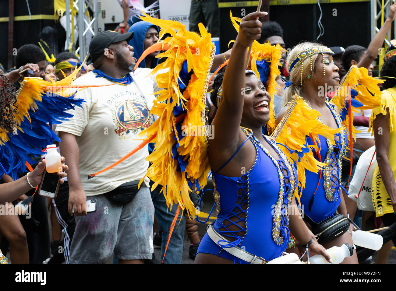 Tanzend zu lauter Musik laufen Teilnehmer der West Indian Day Parade in New York City an den Zuschauern vorbei und animieren diese. Stock Photo