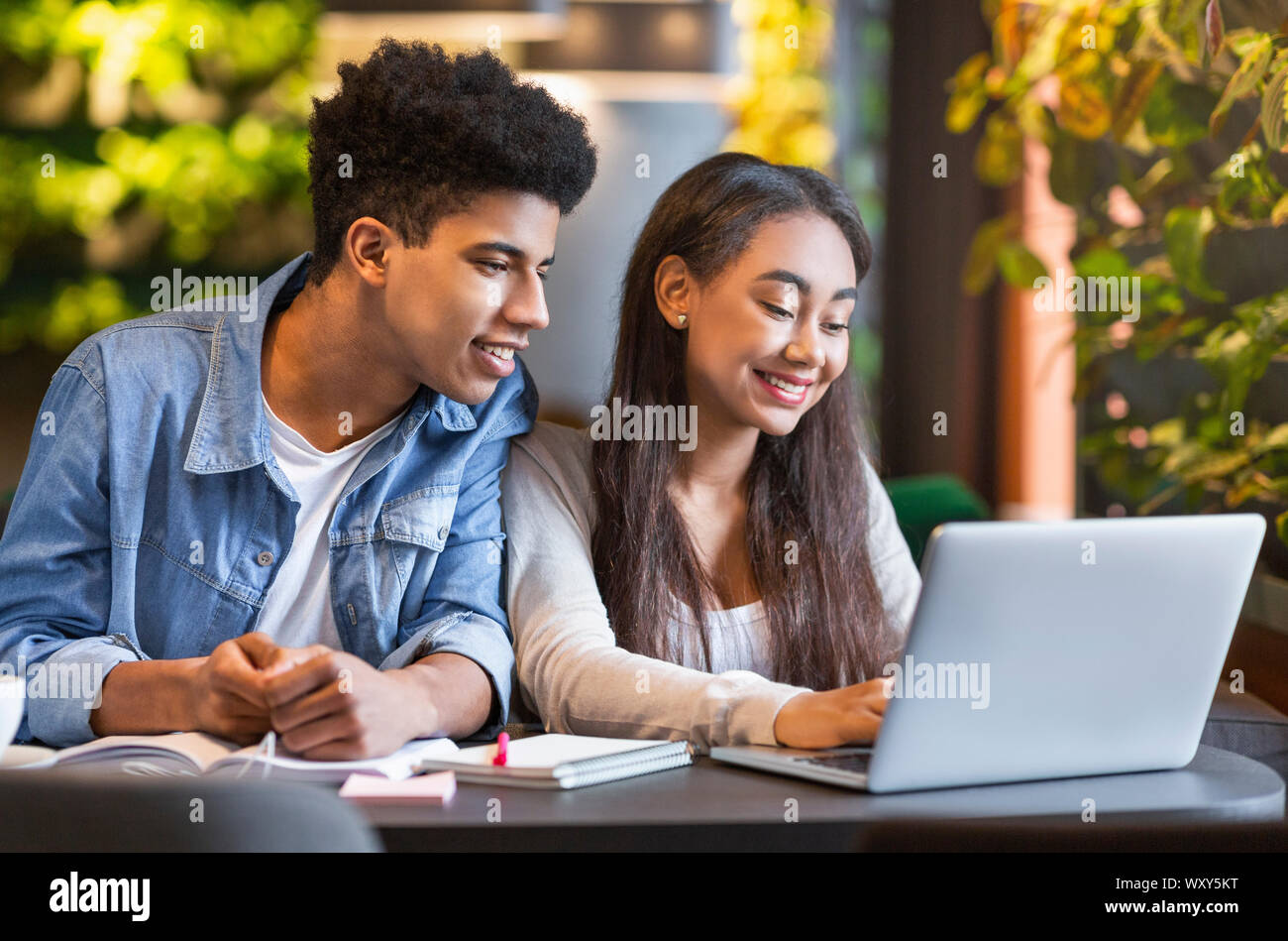 Studying students looking at laptop and smiling Stock Photo