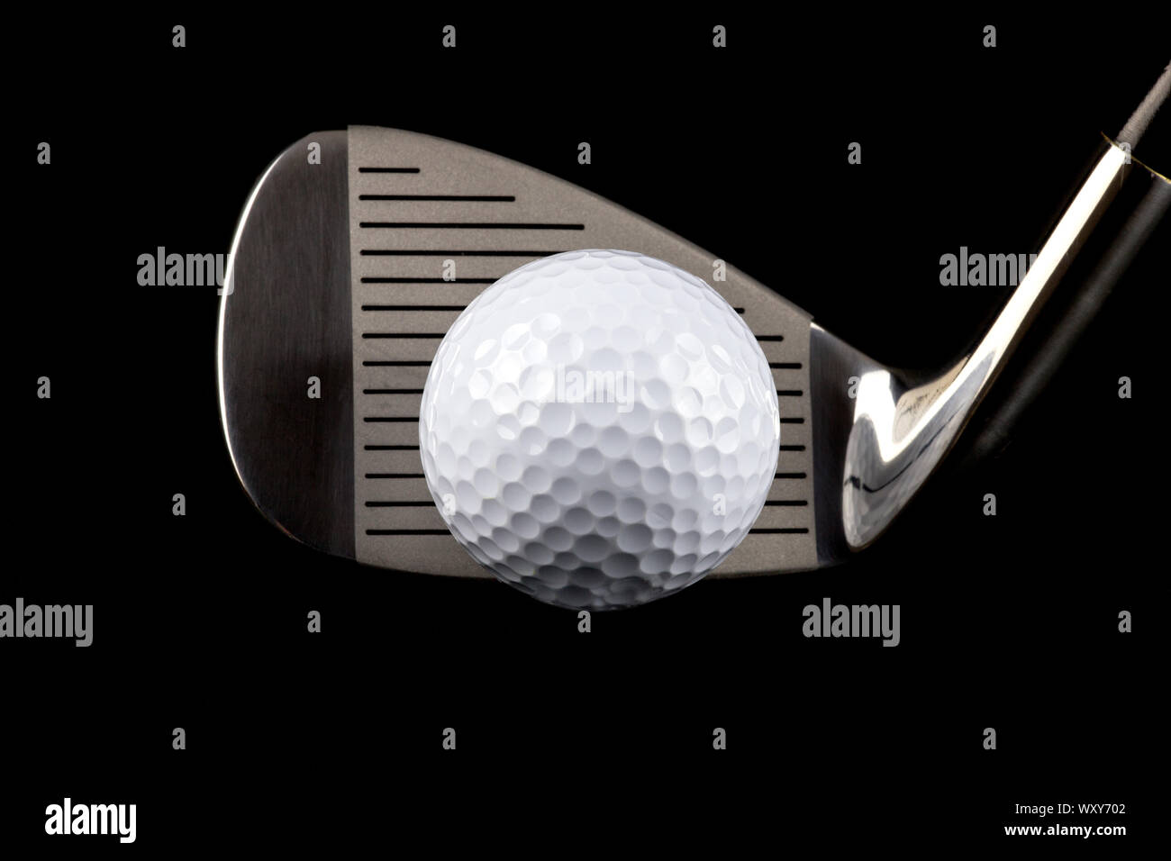 Golf club and golf ball isolated against a black background Stock Photo