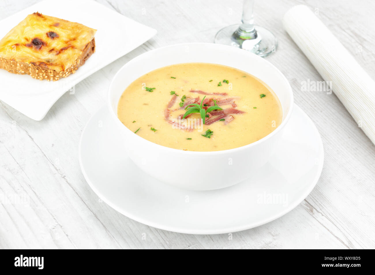 Yellow split pea cream soup with bacon and basil Stock Photo