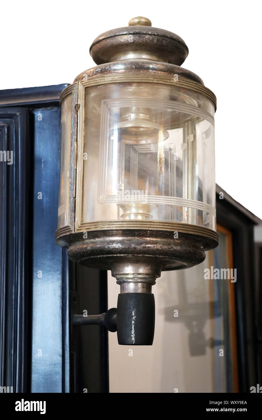 Close up view of brass candle powered headlamp on old cart. Isolated