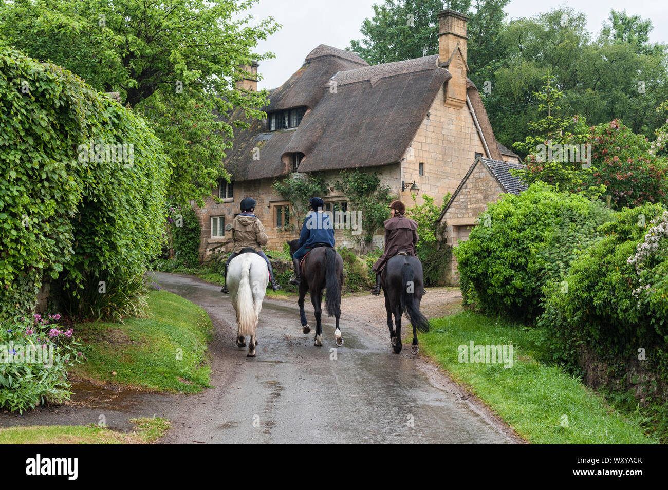 STANTON, ENGLAND - MAY, 26 2018:  Unidentifed people and horses near cottages in the village of Stanton, Cotswolds district of Gloucestershire. Stock Photo