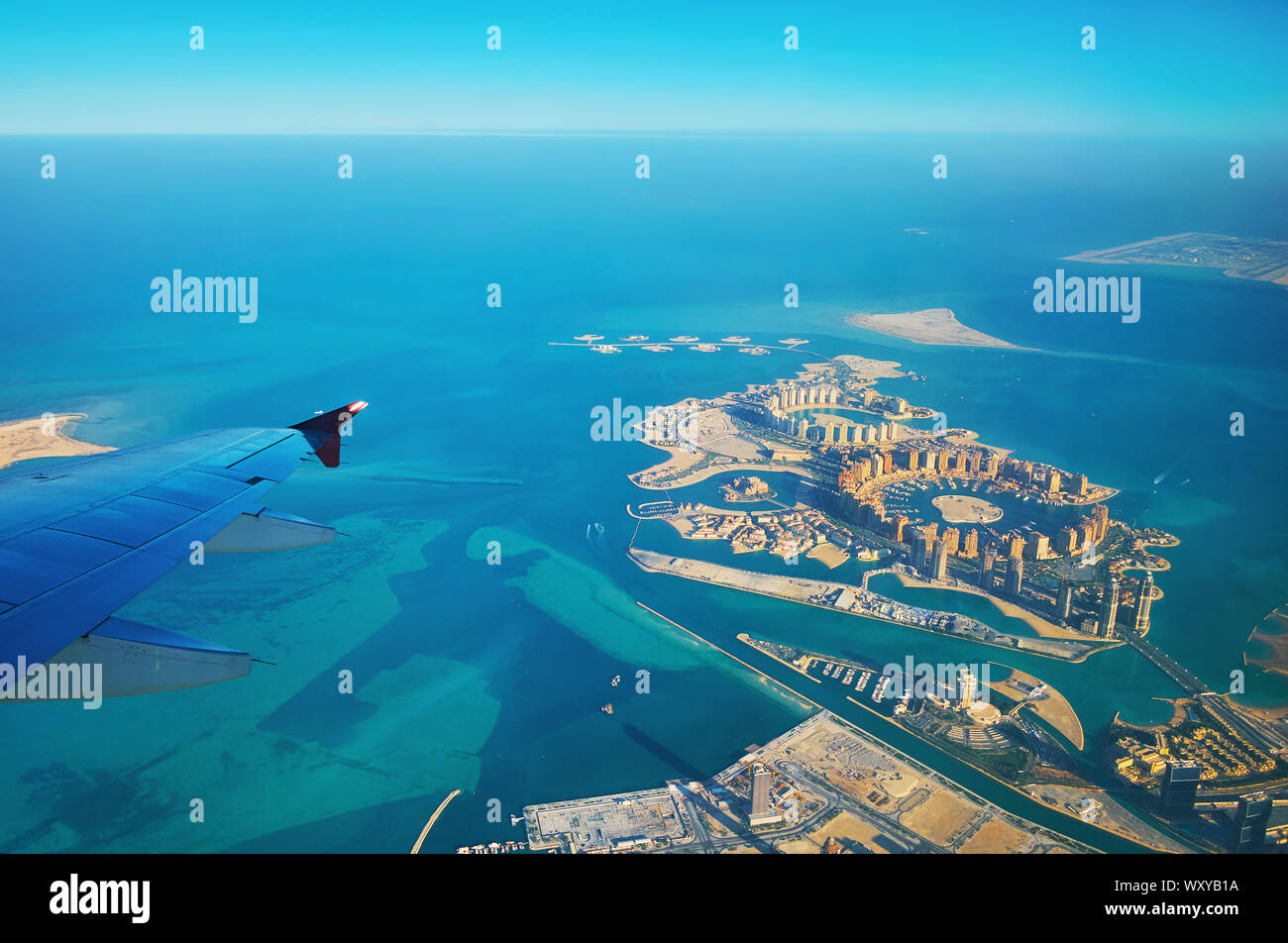 Aerial view on turquoise waters of Persian Gulf and Pearl-Qatar artificial island with luxury hotels, harbors, malls, Isola Dana islets, Porto Arabia Stock Photo
