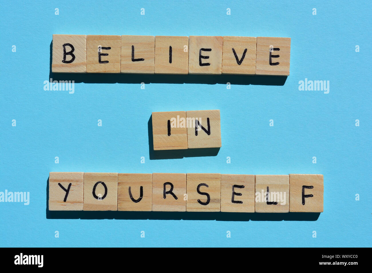 Believe in Yourself, motivational quote in wooden alphabet letters on a blue background Stock Photo