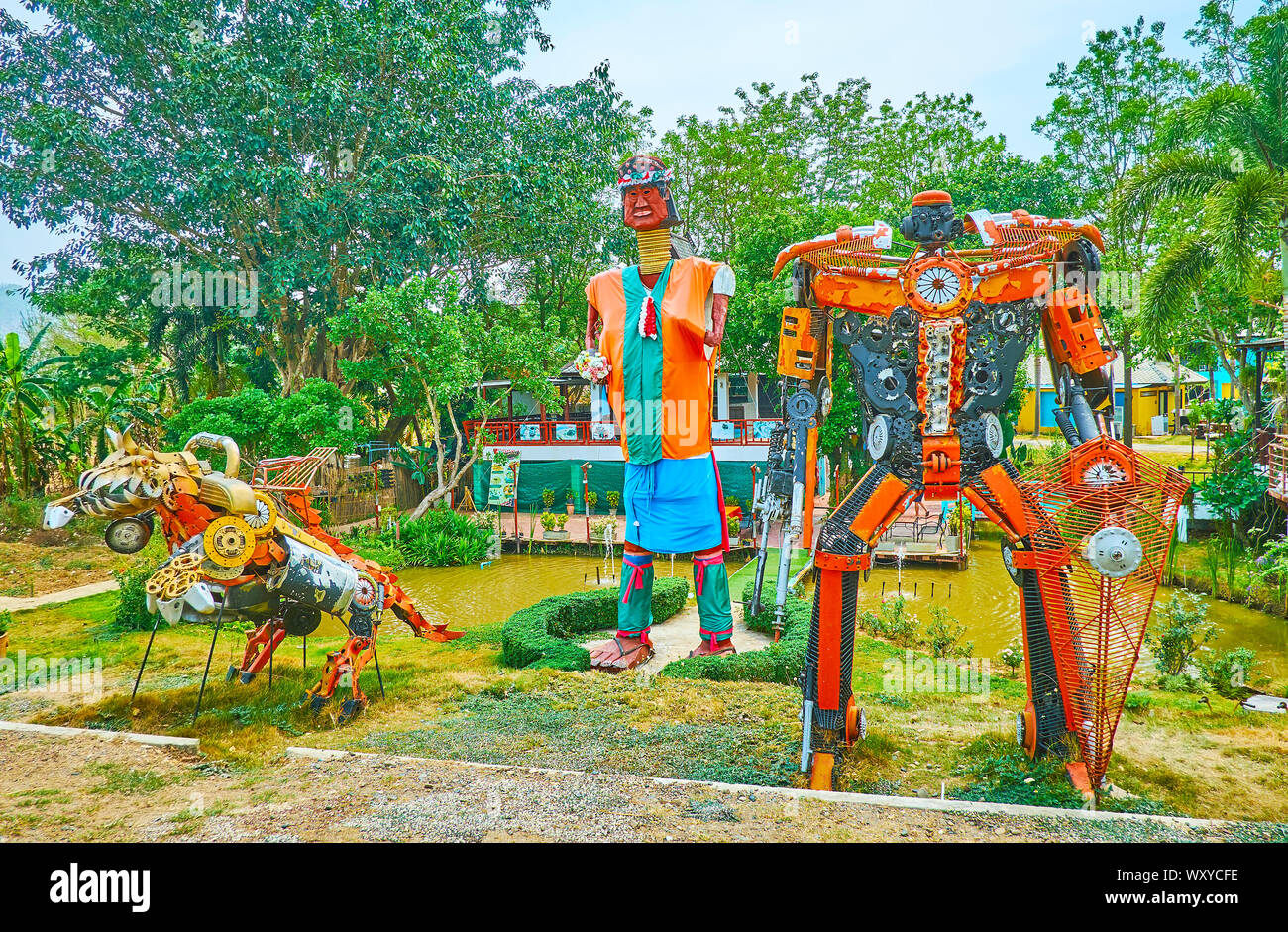 PAI, THAILAND - MAY 5, 2019: The scenic park with small ponds and interesing installations of transformer robots and Karen tribe long neck woman, on M Stock Photo