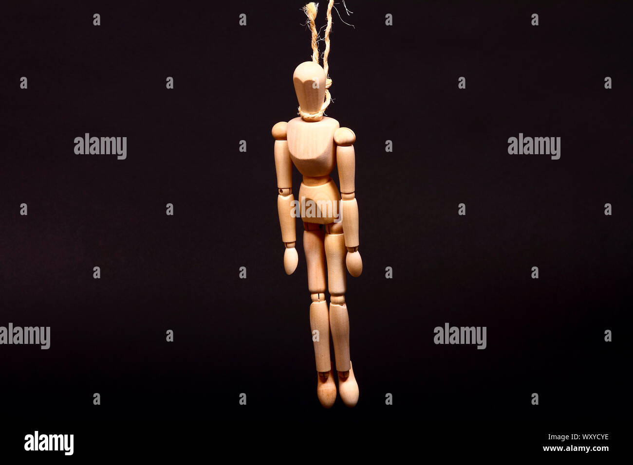 Conceptual image of a manikin hanging from a noose made from rope with space for copy Stock Photo