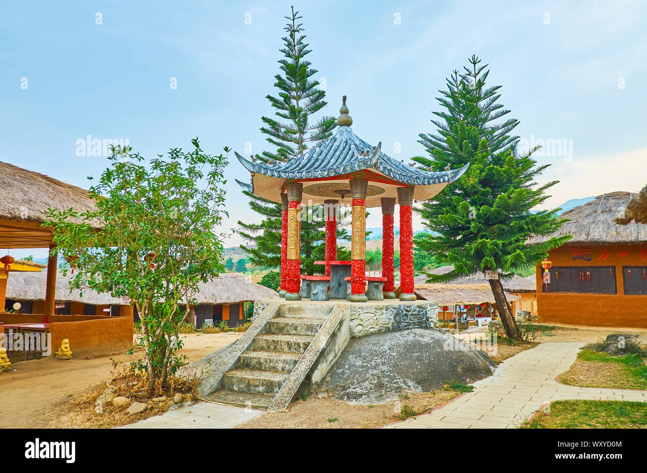 SANTICHON, THAILAND - MAY 5, 2019: The small pavilion with sweeping roof and carved red columns, standing on the pedestal in Chinese Cultural Center p Stock Photo
