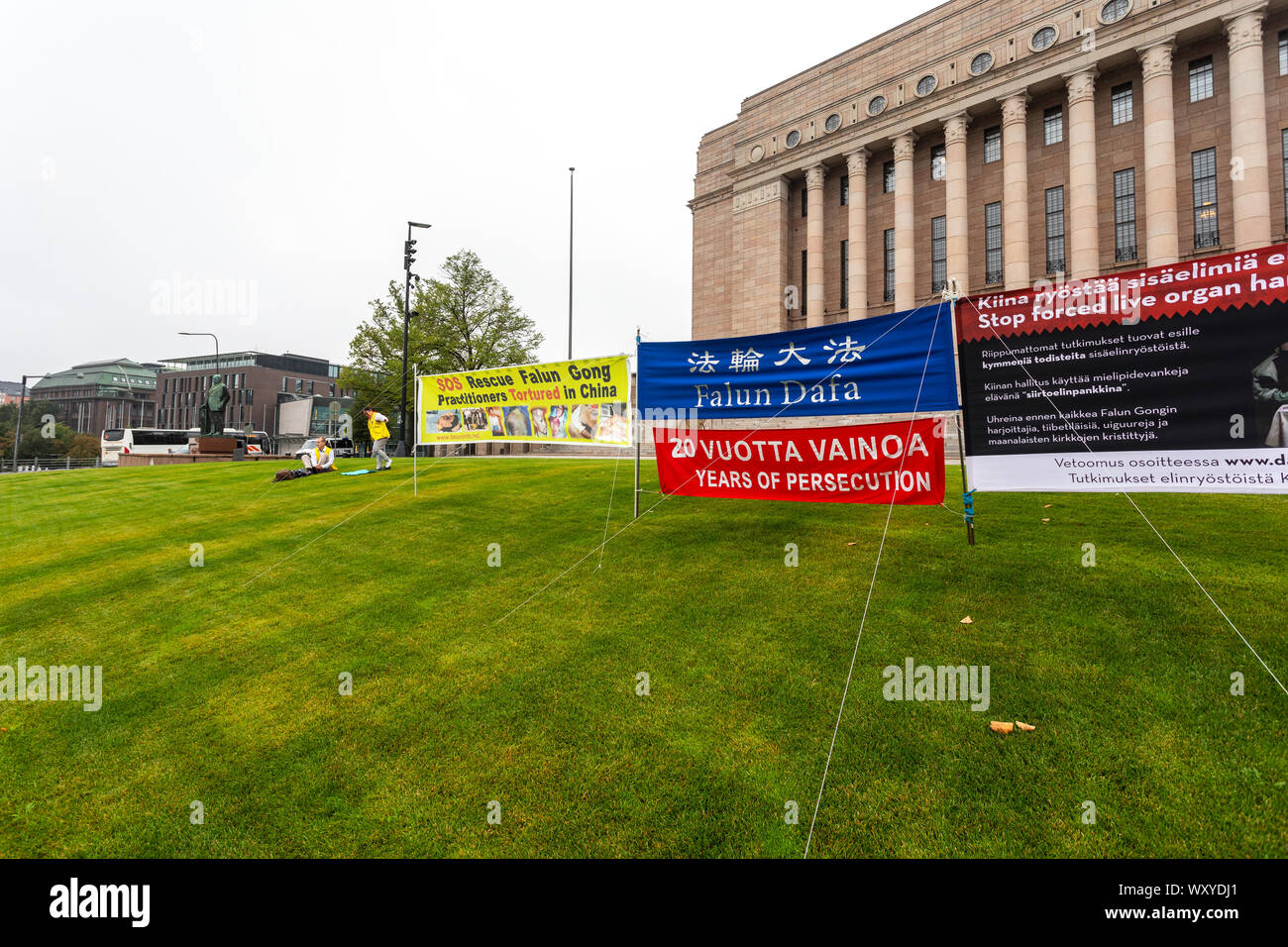 Falun Gong protest in front of Parliament House, Helsinki, Finland 2019. Banner reads: Rescue Falun Gong Practitioner Tortured in China Stock Photo