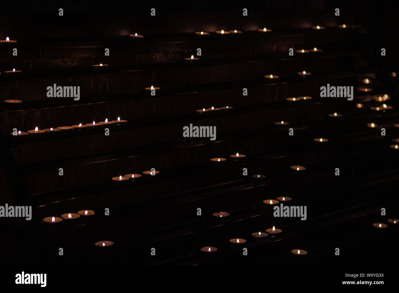 Large group of burning candles at a black background Stock Photo - Alamy