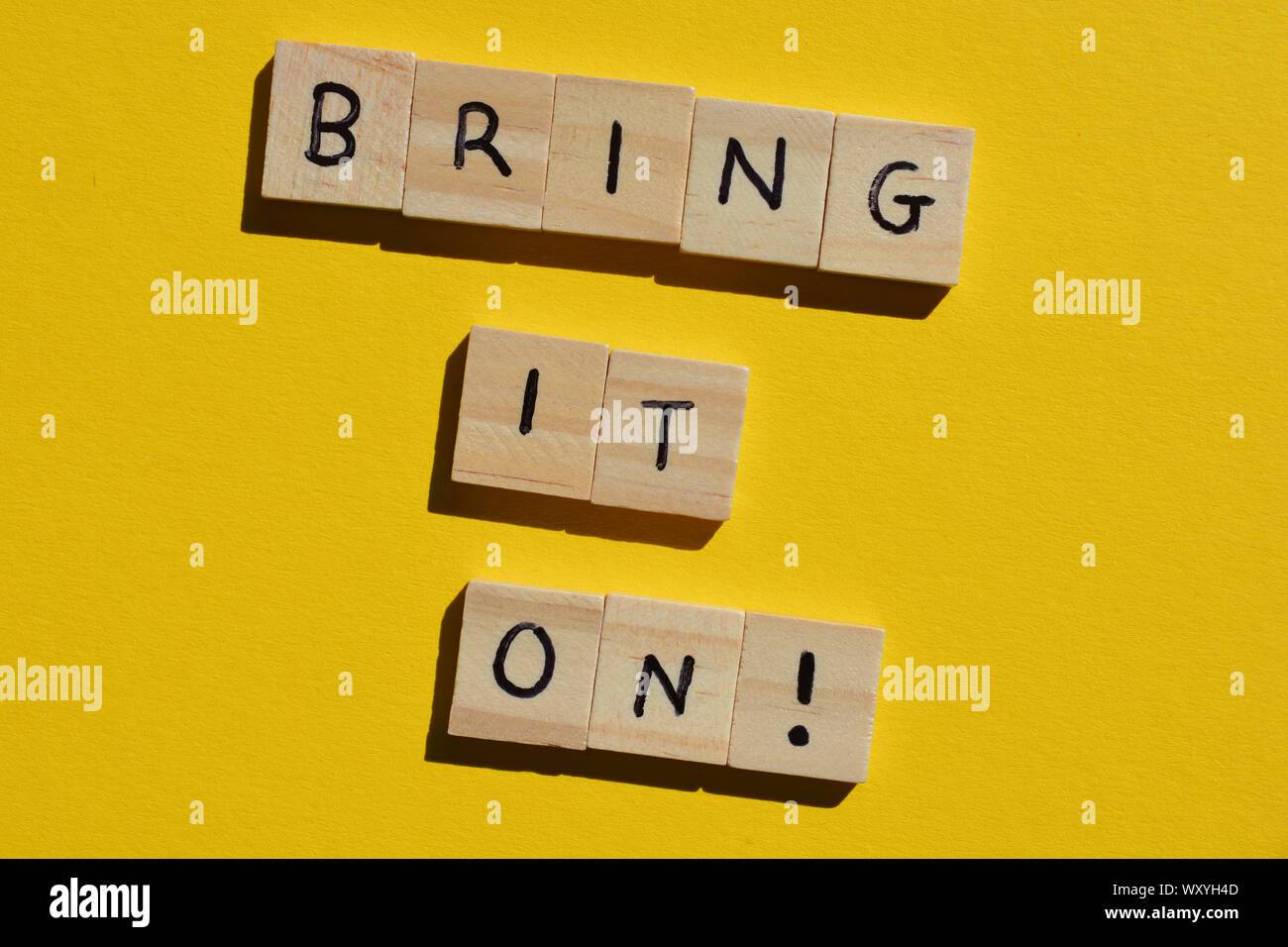 Bring it On, Motivational quote in wooden alphabet letters on a yellow background Stock Photo