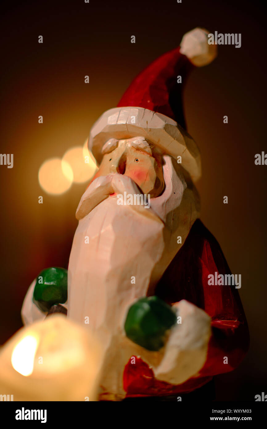 santa claus decoration in front of candle lights Stock Photo