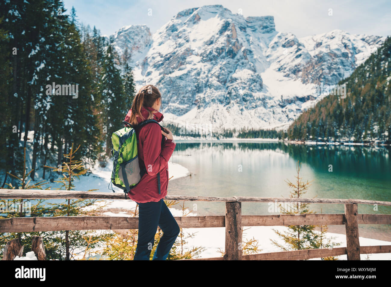 Woman with backpack near lake with azure water in autumn Stock Photo