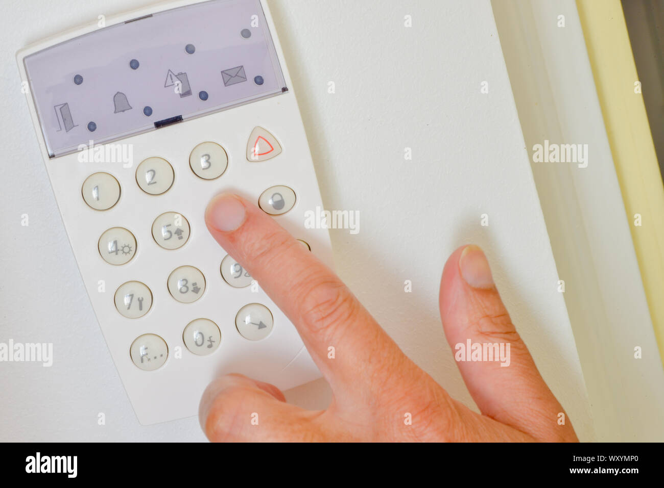 Hand is setting home security alarm system Stock Photo