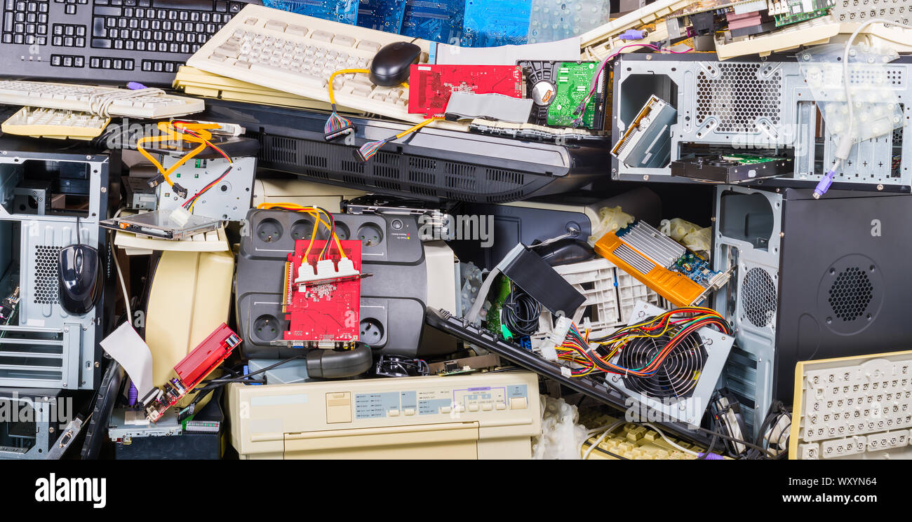 E-waste heap of used computer parts. Refuse separation and recycling. Obsolete or discarded PC hardware such as printers, chassis, keyboards and mice. Stock Photo