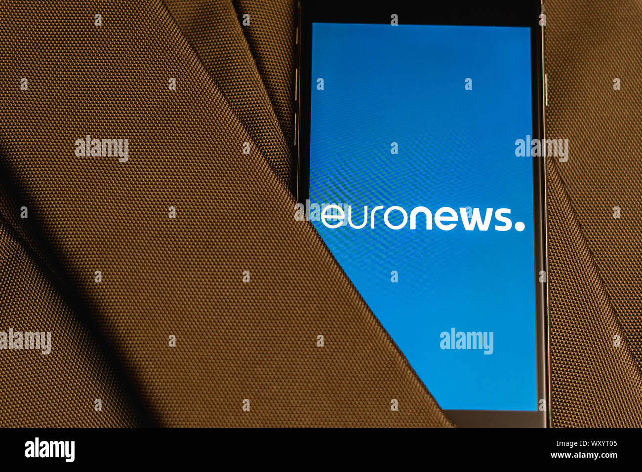 Black phone with logo of News media Euronews on the screen. News media icon. Canvas texture background. Illustration for marketing or business concept Stock Photo
