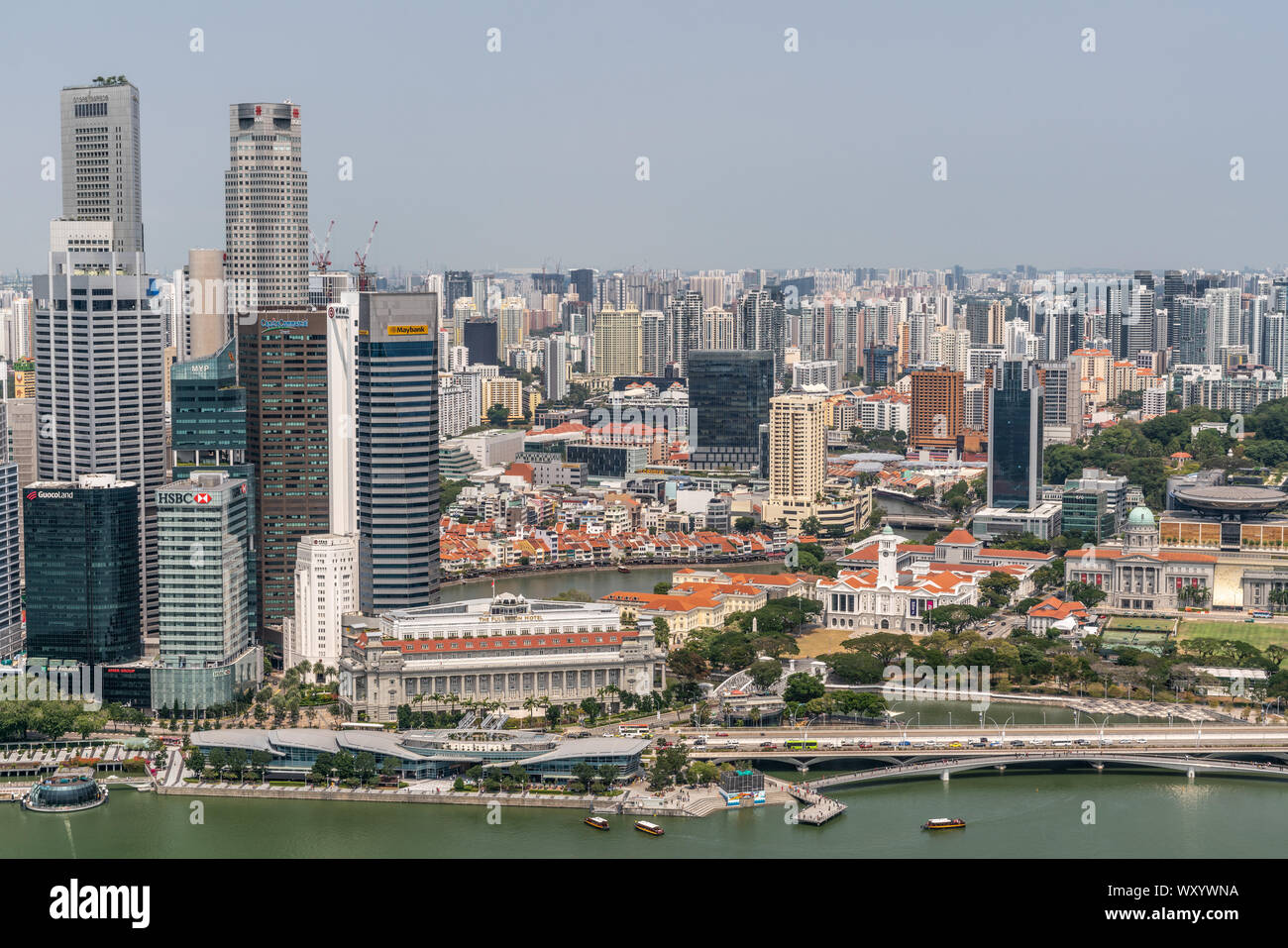 Singapore - March 21, 2019: Shot from Sands roof. Birds eye view Fullerton Hotel with river behind and greenish marina in front. Part of Financial dis Stock Photo