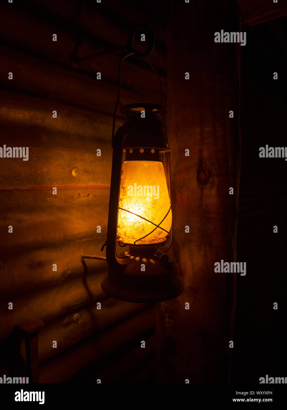 Old retro kerosene lantern with a corrugated iron wall background and dark background Stock Photo