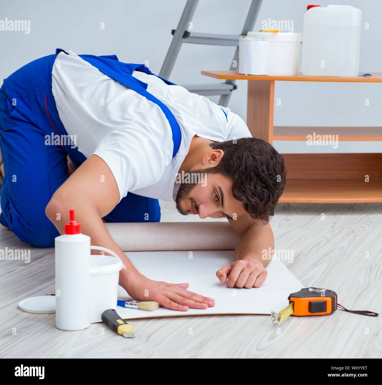 Repairman doing renovation repair in the house with paper wallpaper ...