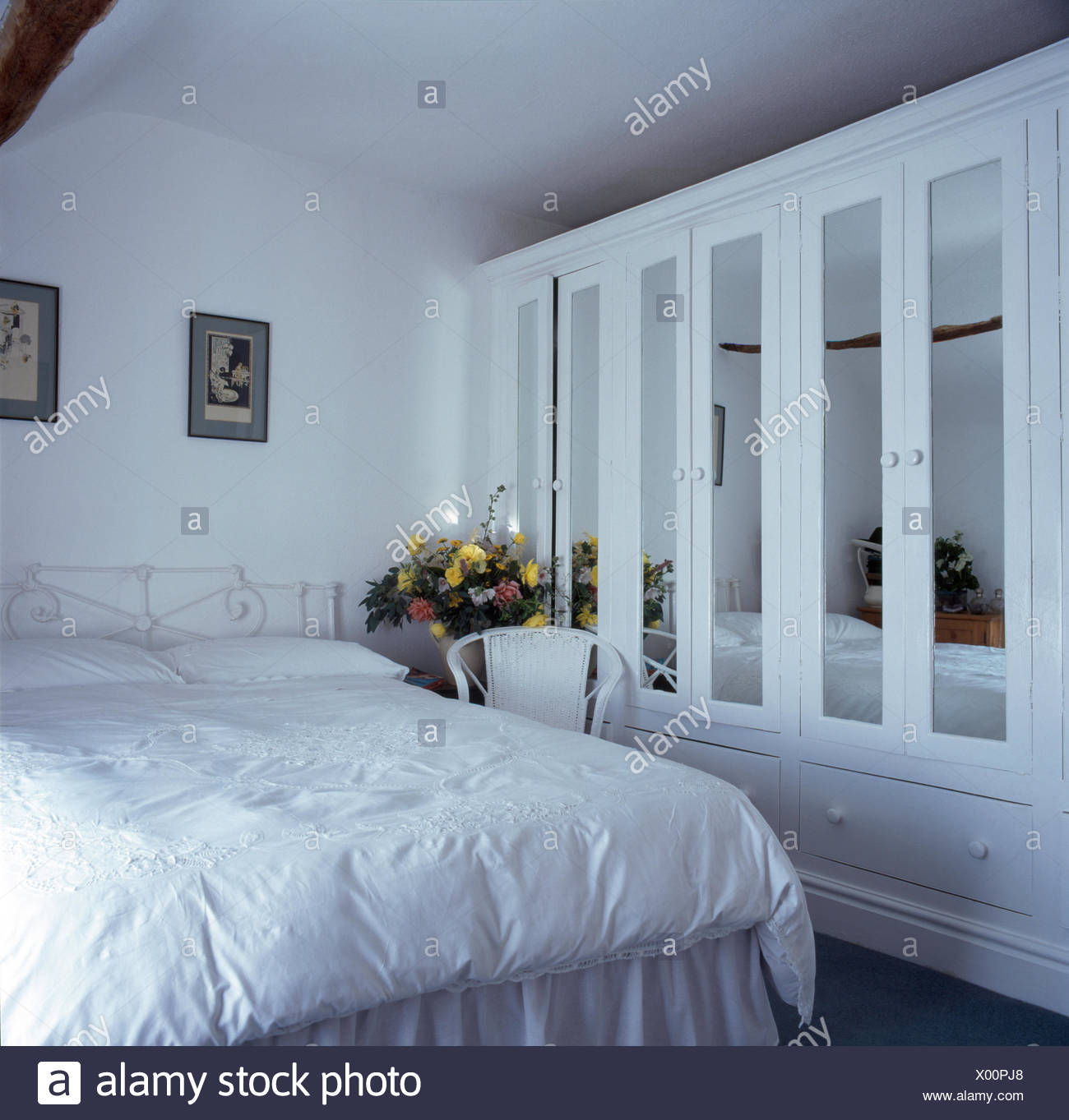 Mirrored Panels In Doors Of Fitted Wardrobe In An All White