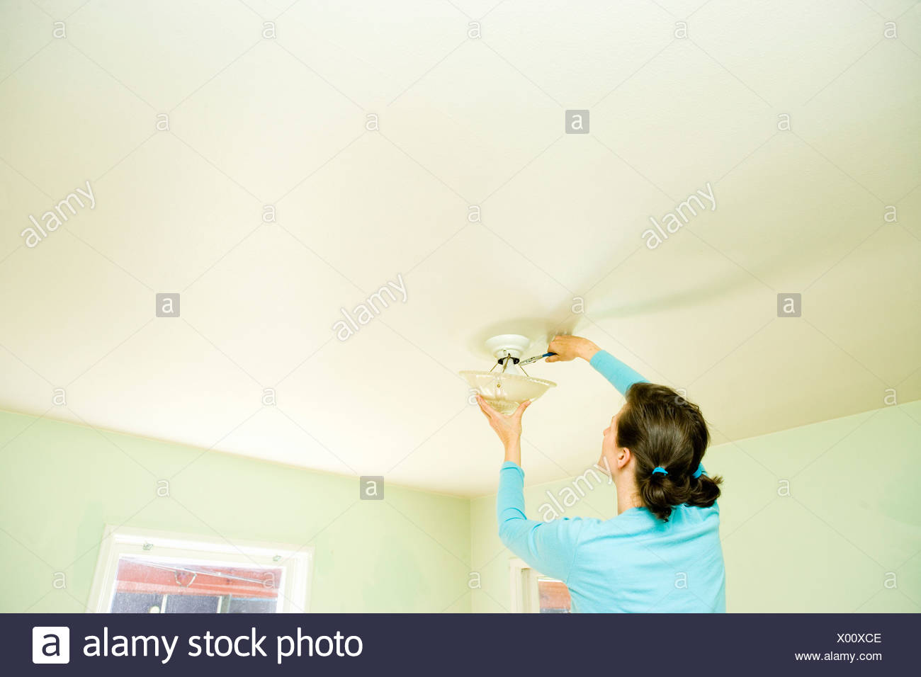 Woman Repairing Light Fixture On Ceiling Stock Photo 275386622 Alamy Woman Repairing Light Fixture On Ceiling