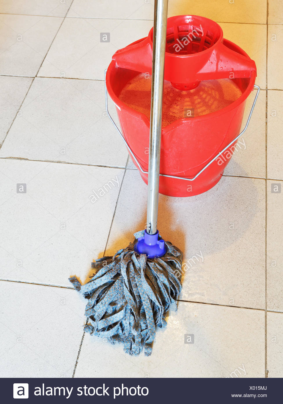 Red Bucket With Foamy Water And Mopping The Tile Floors Stock