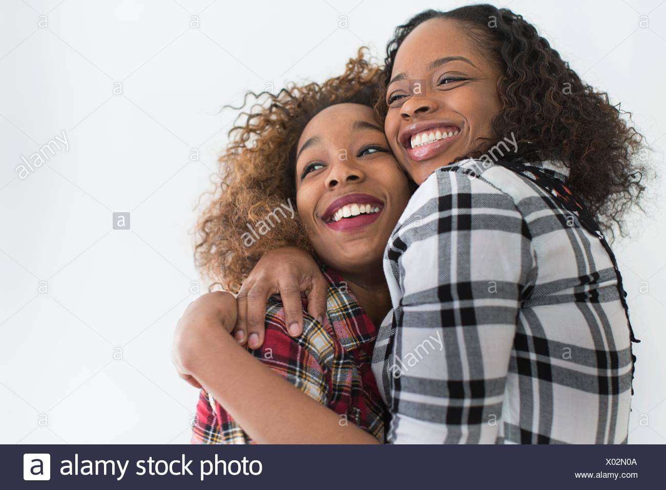 Studio portrait of two young women friends hugging Stock Photo