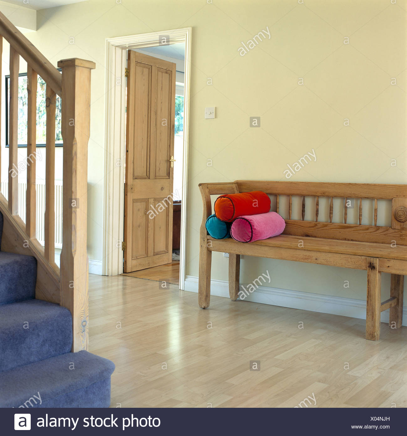 Wooden Settle With Velvet Bolster Cushions In Spacious Hall With
