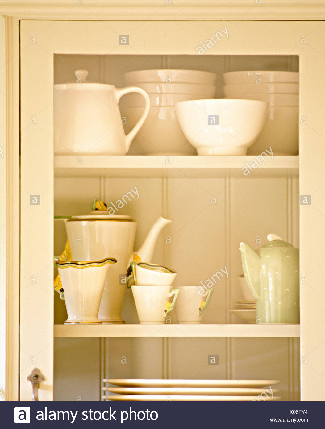 Glass Door On Recessed Kitchen Cupboard With Cream Bowls And An Art Deco Tea Service Stock Photo Alamy