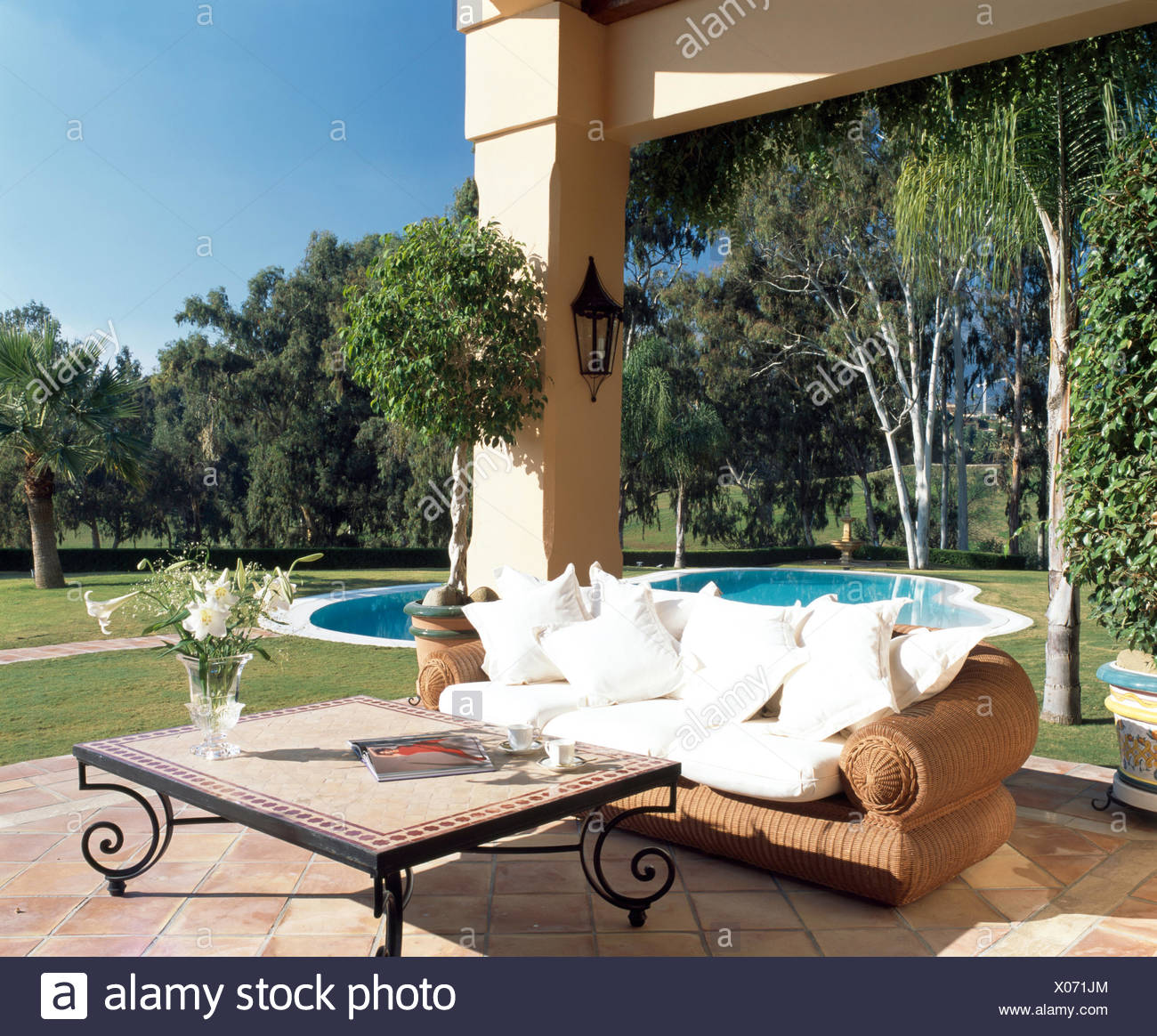 Wicker Sofa With White Cushions Beside Metal Coffee Table On Paved Terrace Of Large Spanish Villa Stock Photo Alamy