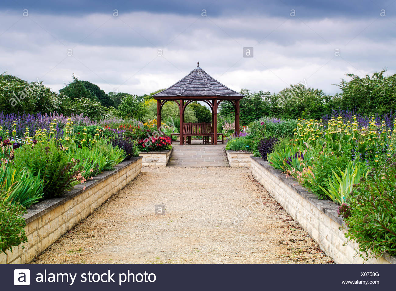 A Garden With Raised Beds And A Seating Area Stock Photo
