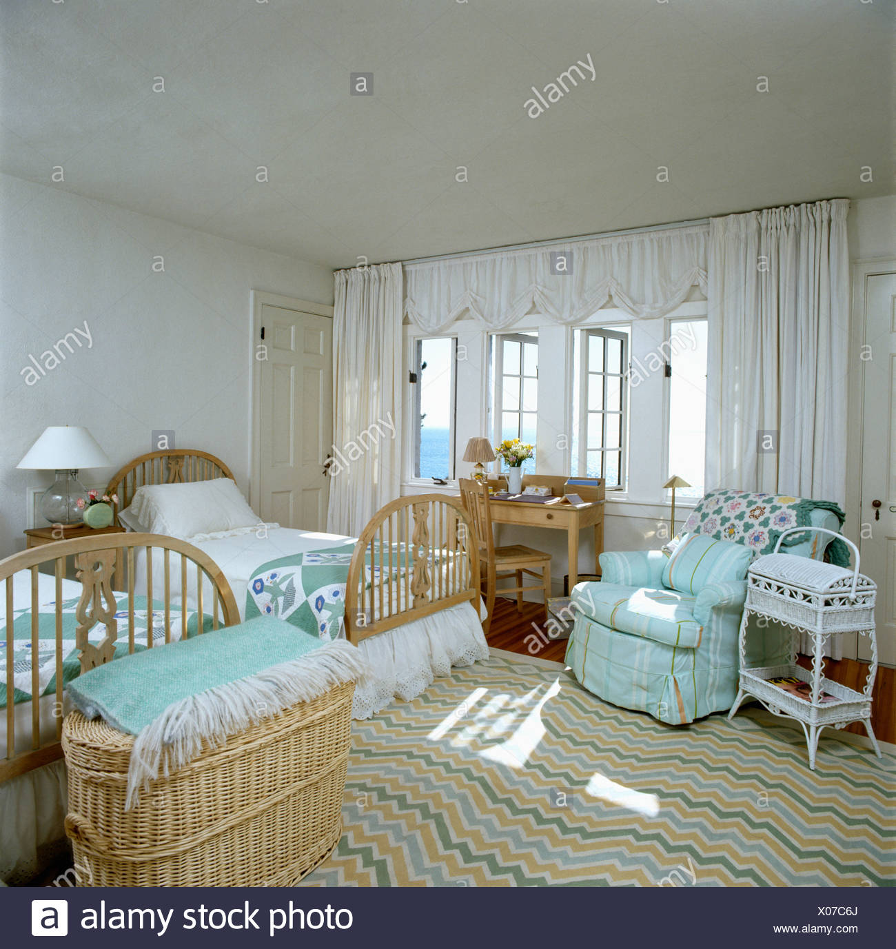 Twin Beds In Seaside Bedroom With Turquoise Armchair And