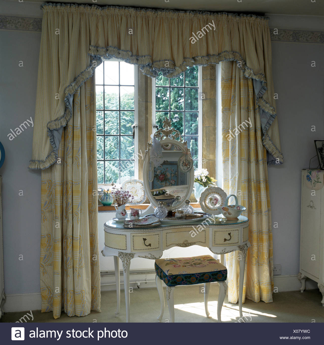 Oval Mirror On White Painted Dressing Table In Bedroom Window With