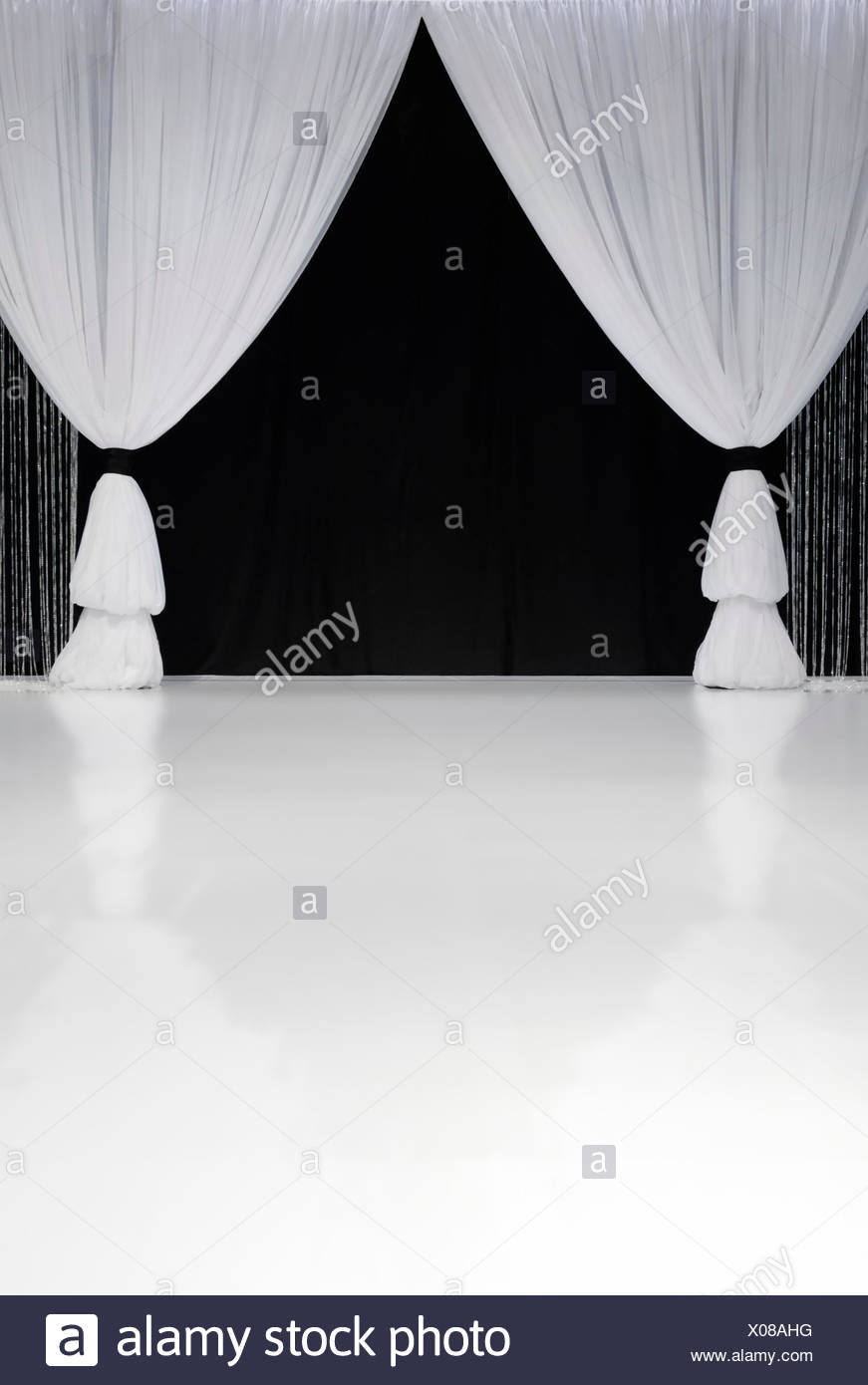White Stage Curtains In Front Of Black Curtains Stock Photo