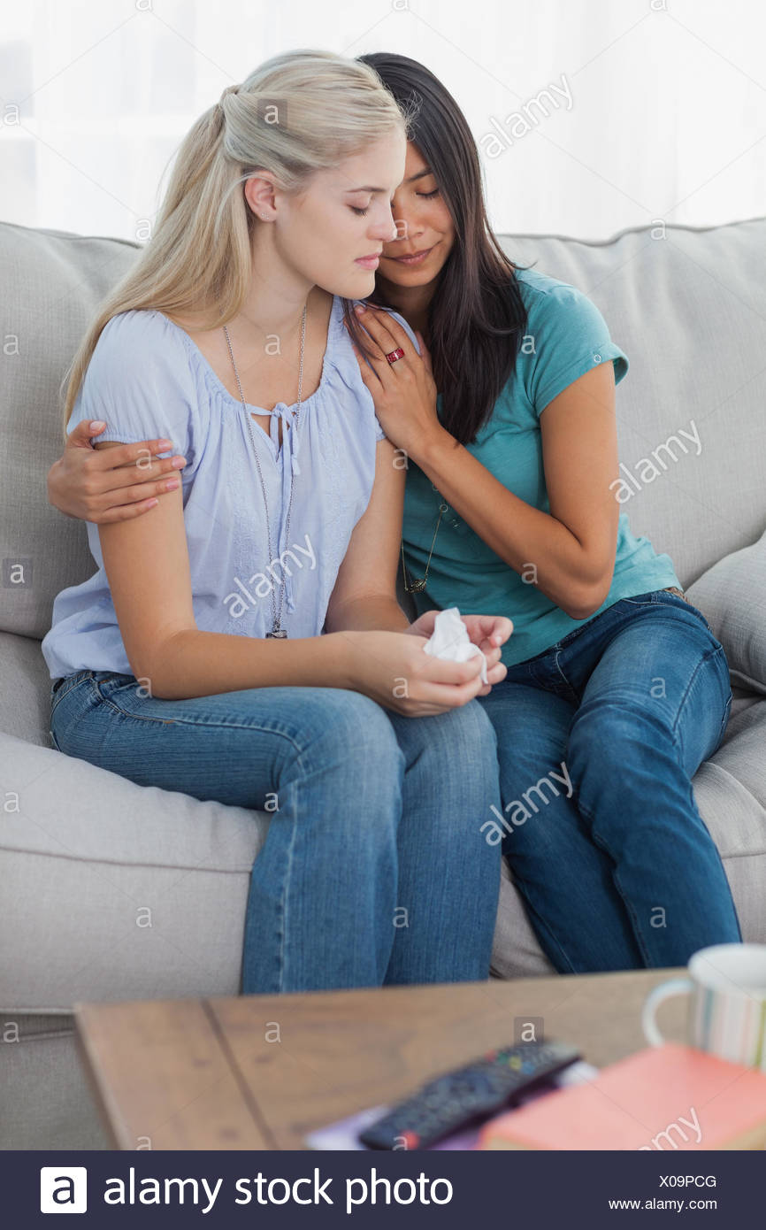 Concerned Woman Comforting And Hugging Her Sad Friend At Home On