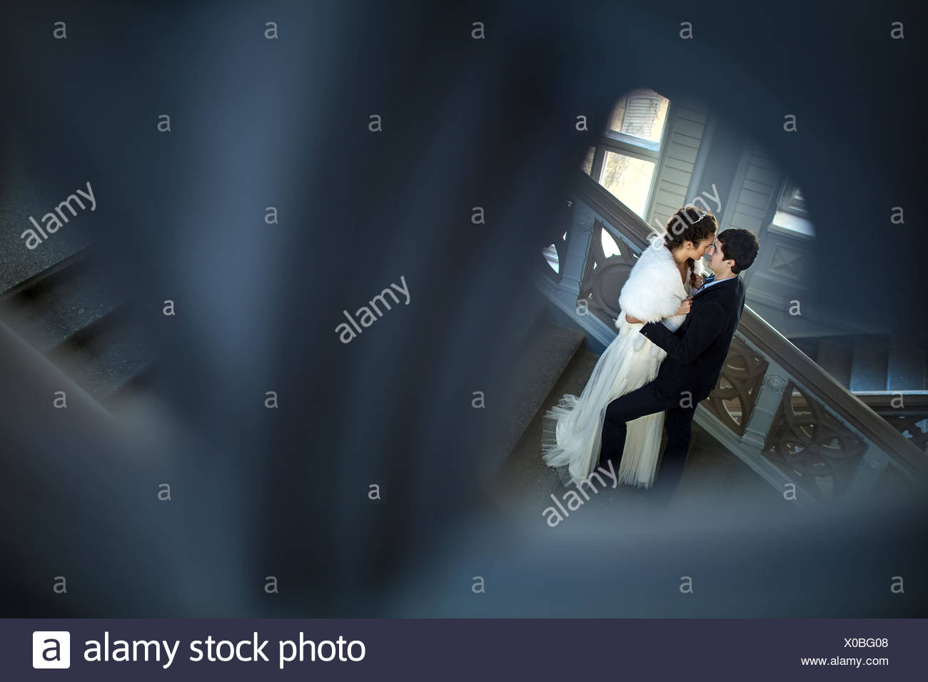 kissing couple in love standing on a ladder X0BG08