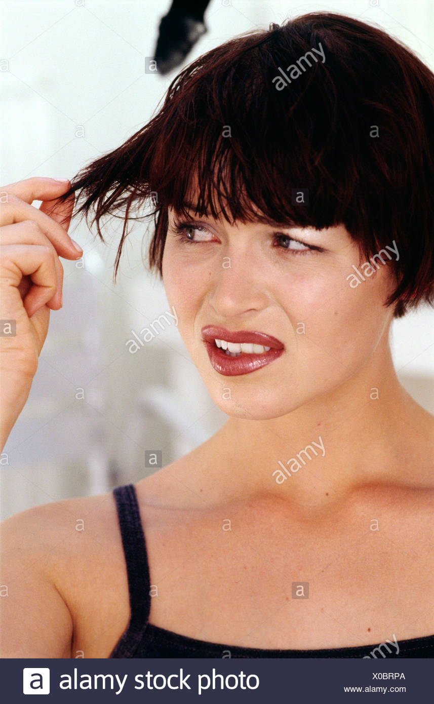 Brunette Female With Short Bob Abd Thick Fringe Pulling A Strand