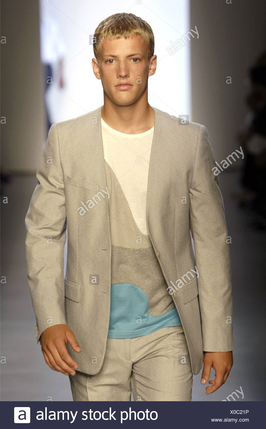 Calvin Klein Milan Ready to Wear Menswear Spring Summer Blonde male model  wearing a blue, grey and cream sweater beneath a Stock Photo - Alamy