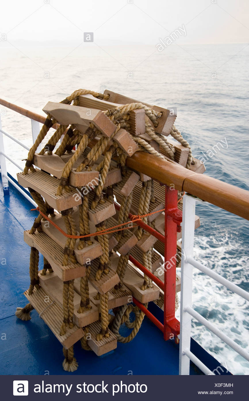 A Rope Ladder Rolled Up Over A Ship Railing Stock Photo