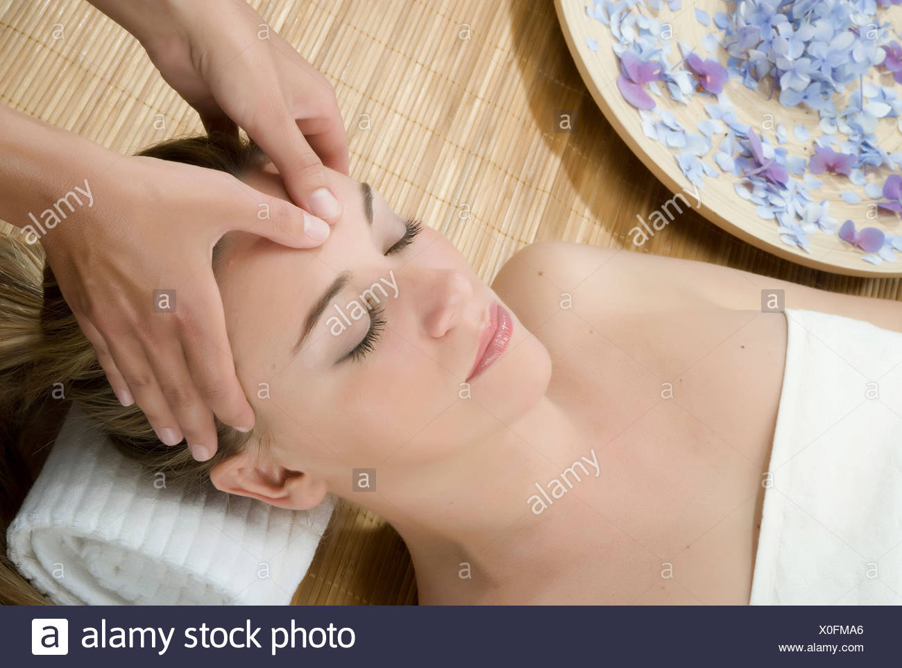 Woman at spa having forehead massaged Stock Photo