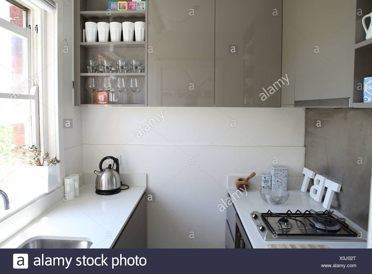 Apartment In Sydney Small Galley Kitchen With White Stone Work Surfaces And Grey Shiny Cupboards Stock Photo Alamy