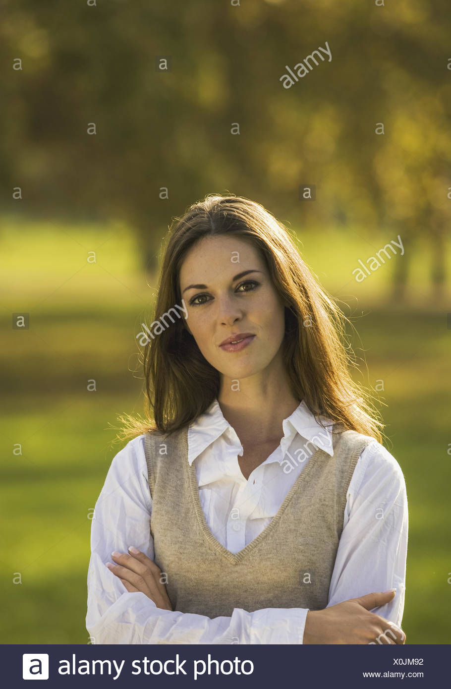 Frau in herbstlichem Park, verschraenkte Arme, Halbportraet (model-released) Stock Photo